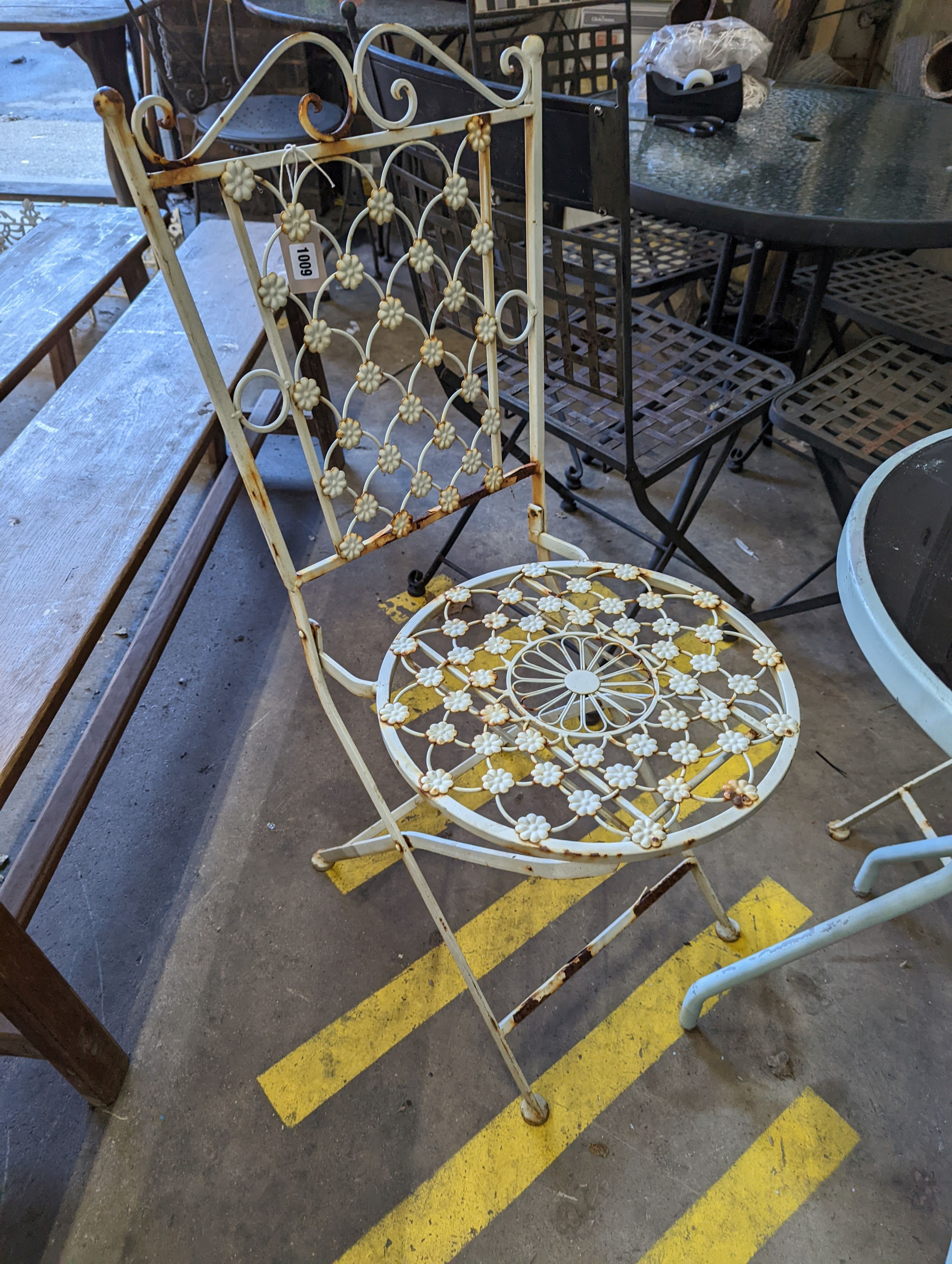 A circular glass top bistro table, diameter 50cm, height 72cm together with two painted metal chairs